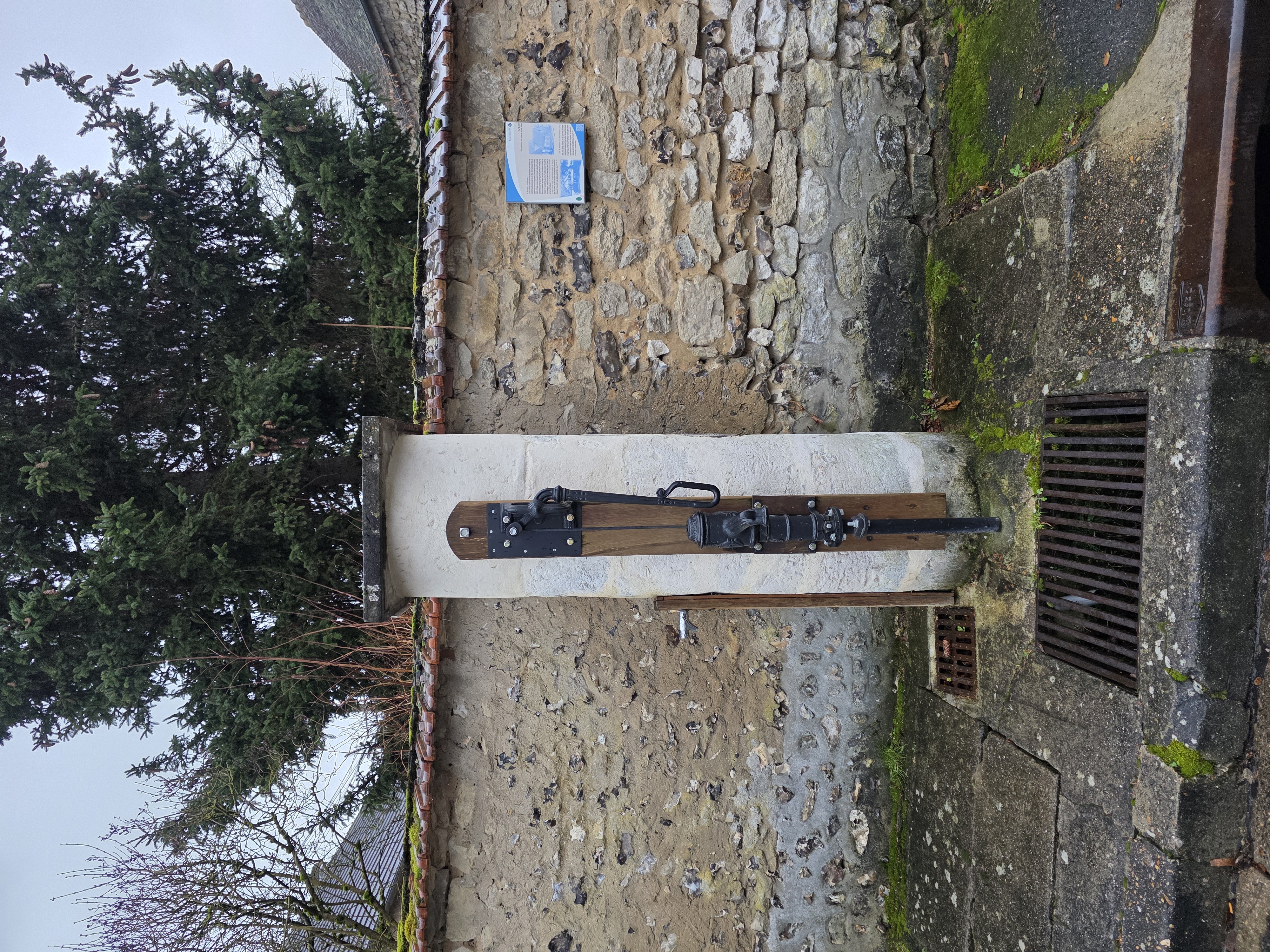 Vue rapprochée de la pompe en fonte adossée au chapiteau colonne-chapelle-pompe-2